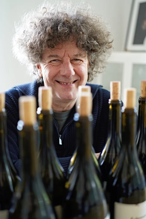 Philippe Pacalet derrière une rangée de bouteilles